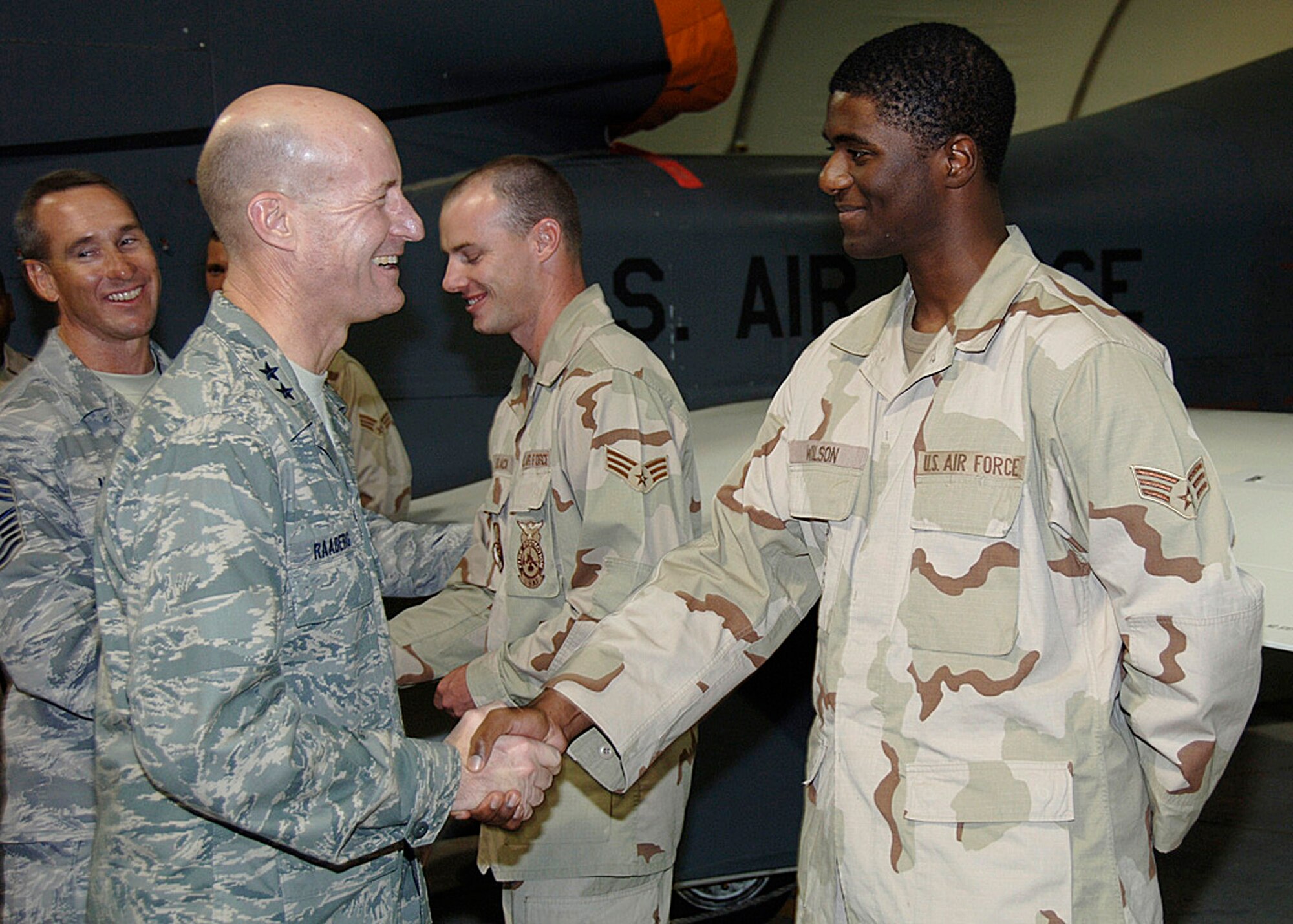 SOUTHWEST ASIA -- Maj.Gen. Douglas Raaberg presents Senior Airman Paul Wilson from the 380th Air Expeditionary Wing with a coin Aug 28. General Raaberg also discussed different events and the role the 380th plays in the  war on terror with Airman Wilson and several other members of the 380th AEW.(U.S. Air Force photo/Tech. Sgt. Christopher A Campbell)(released)