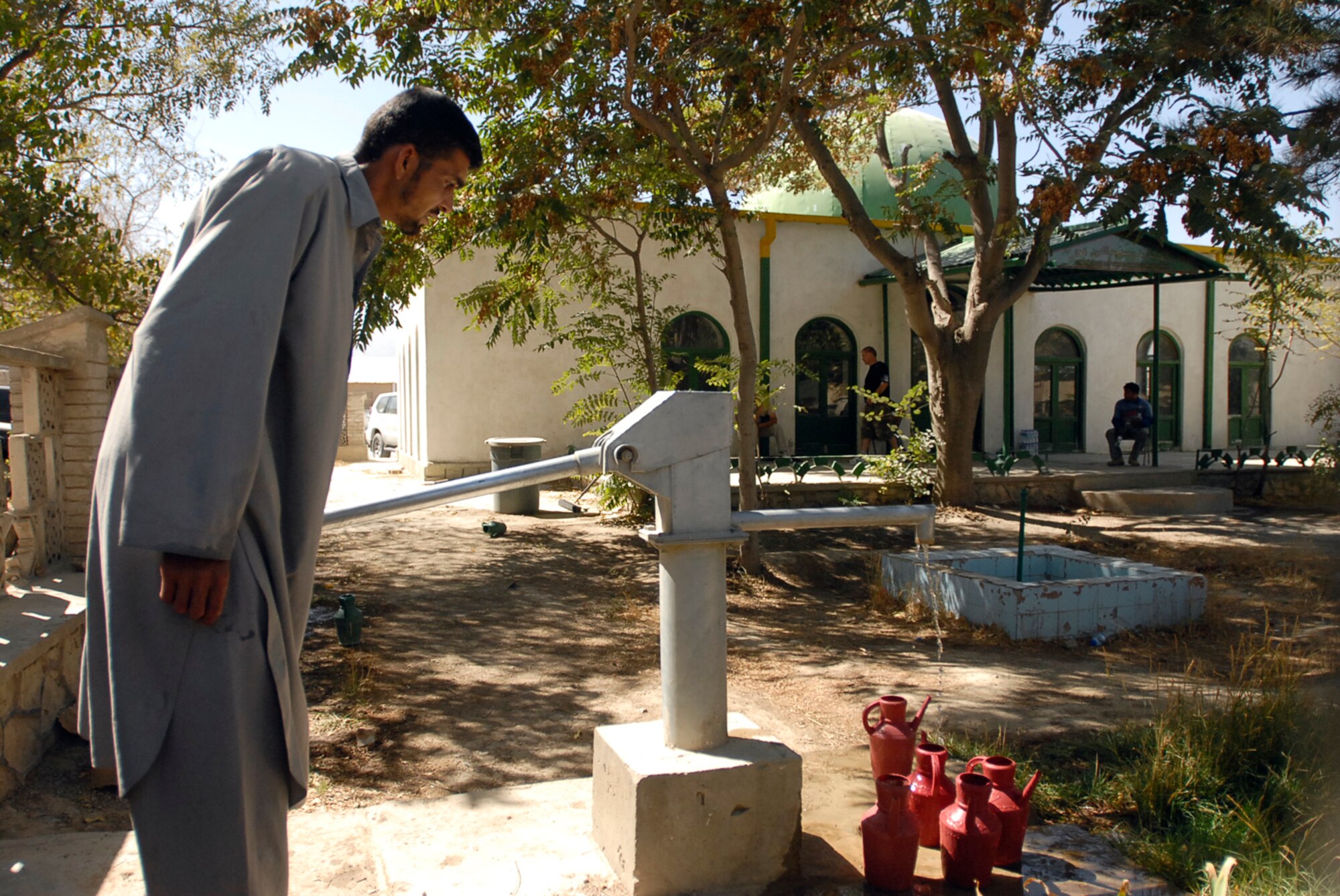 A local Afghan man fills watering cans to water plants growing in the courtyard surrounding the Mosque of Sayed Jamaludin Afghani, a mosque located on Bagram Air Field. (Courtesy photo)