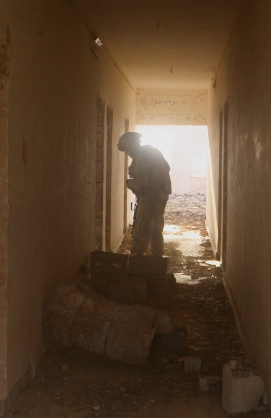 Lance Cpl. Jonathan Higgins, 21, a scout with Alpha Company, 2nd Light Armored Reconnaissance Battalion, Regimental Combat Team 5, searches an abandoned house for weapons caches during a patrol through the desert of western al-Anbar province, Iraq, Sept. 3. The western al-Anbar province has changed for the better since Marines of Alpha Co. have arrived in Iraq.  The caches found have lowered, the oil smuggling has decreased and the people have felt safer because of it.::r::::n::