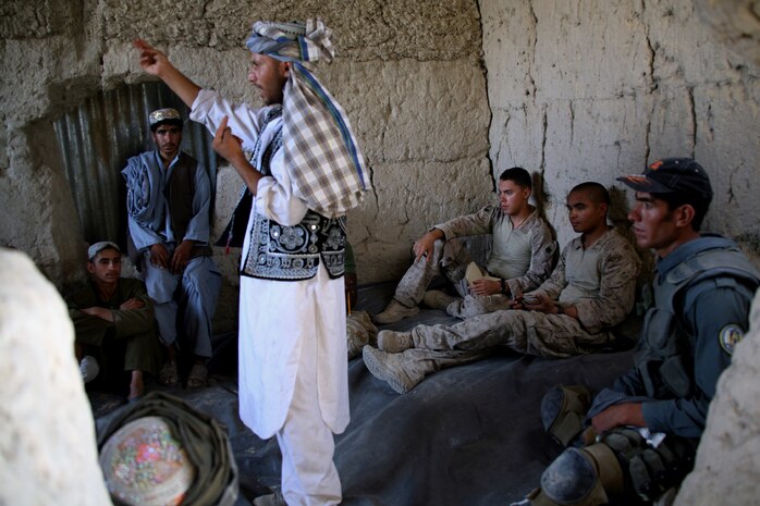 Joined by an interpreter, Cpls. Eric E. Cuevas and Jeff B. Varsovia, both assigned to 3rd Civil Affairs Group, listen to local concerns by teenage males, the demographic most susceptible to Taliban influence.