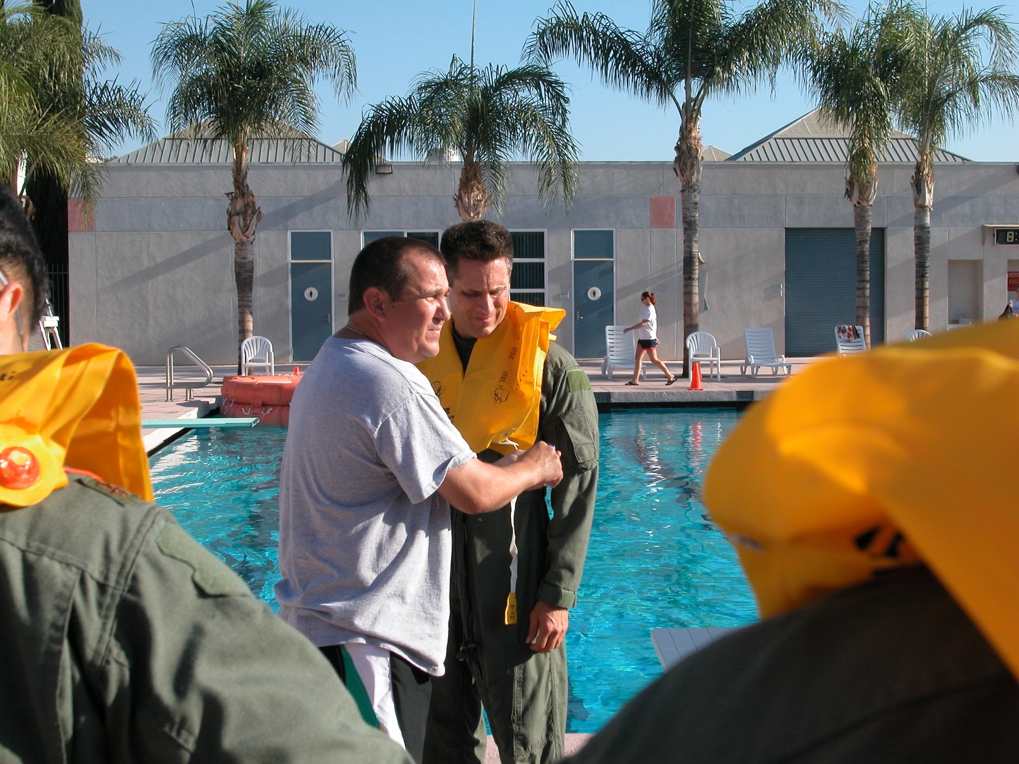 Tech. Sgt. Lawrence E. Hill, demonstrates to students how to adjust the Adult/Child Life Preservers with Lt. Col. Charles Assuma, commander, 452 OSS. (U.S. Air Force photo by Staff Sgt. Joe Davidson, 452 AMW/PA)