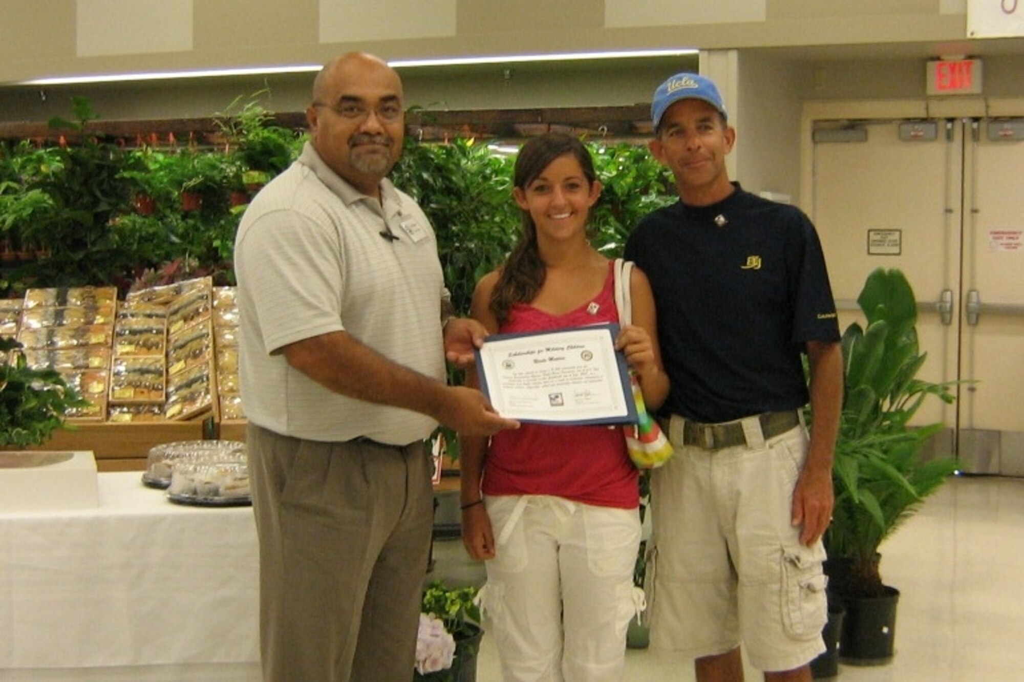 SCHOLAR/ATHLETE: Nicole Matera, daughter of Col. Gene Matera, Fourth Air Force/IG (right), accepts a $1,500 scholarship from Phil Ruiz, store director, March ARB Commissary. (U.S. Air Force photo)