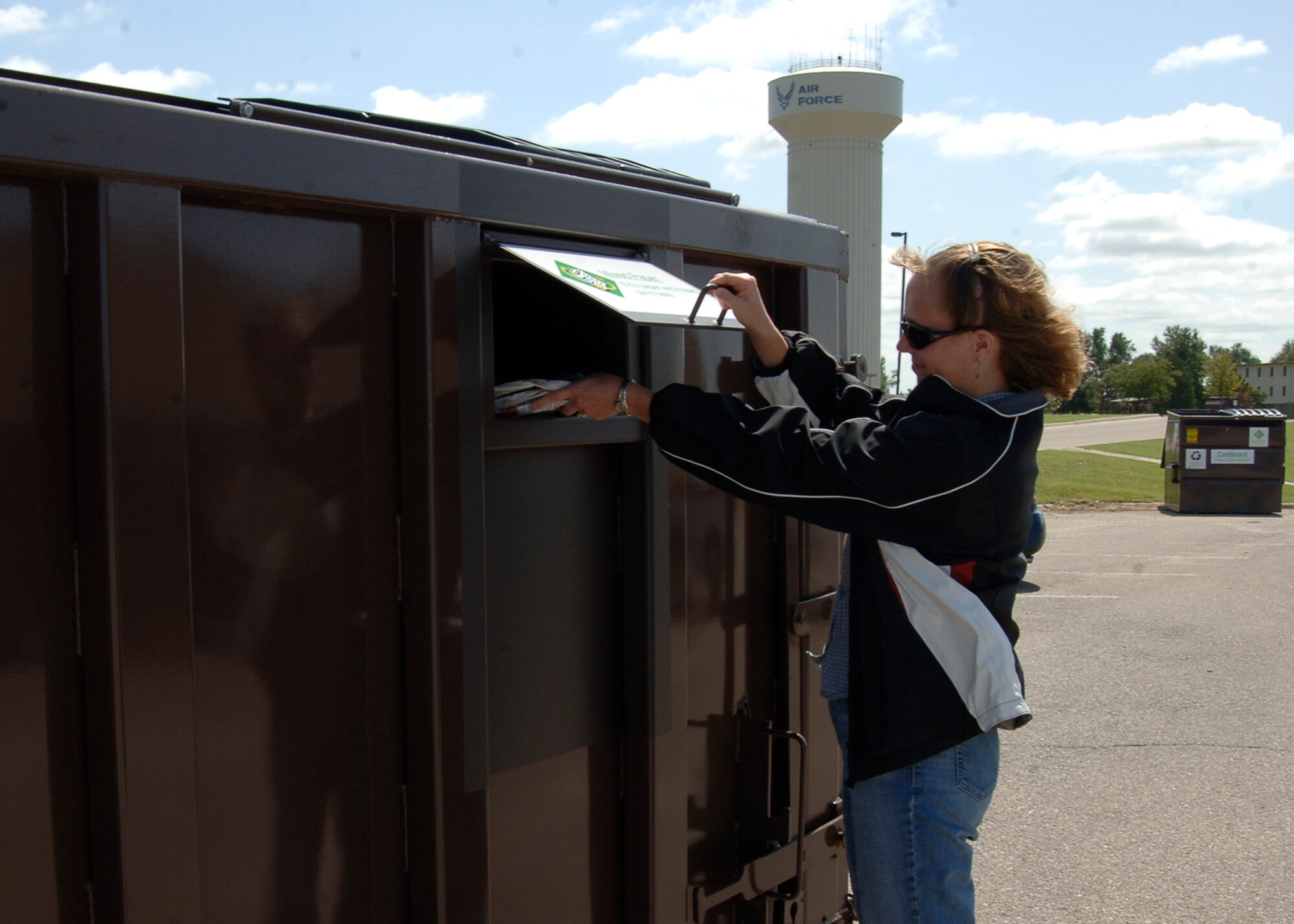 MCCONNELL AIR FORCE BASE, Kan. --Kristi Draney, 22nd Civil Engineering Squadron, recycles assorted papers in the commissary parking lot at one of nine roll off recycling containers, Sept. 4. The commissary’s unit is the first to receive new upgrades, Ms. Draney is the recycling program manager and has coordinated all nine units to be upgraded with more convenient access, the containers are located in such places as the Robert J. Dole Community Center and dormitory parking lots, north and south of building 1090 and behind building 850. (Photo by Airman Justin Shelton)