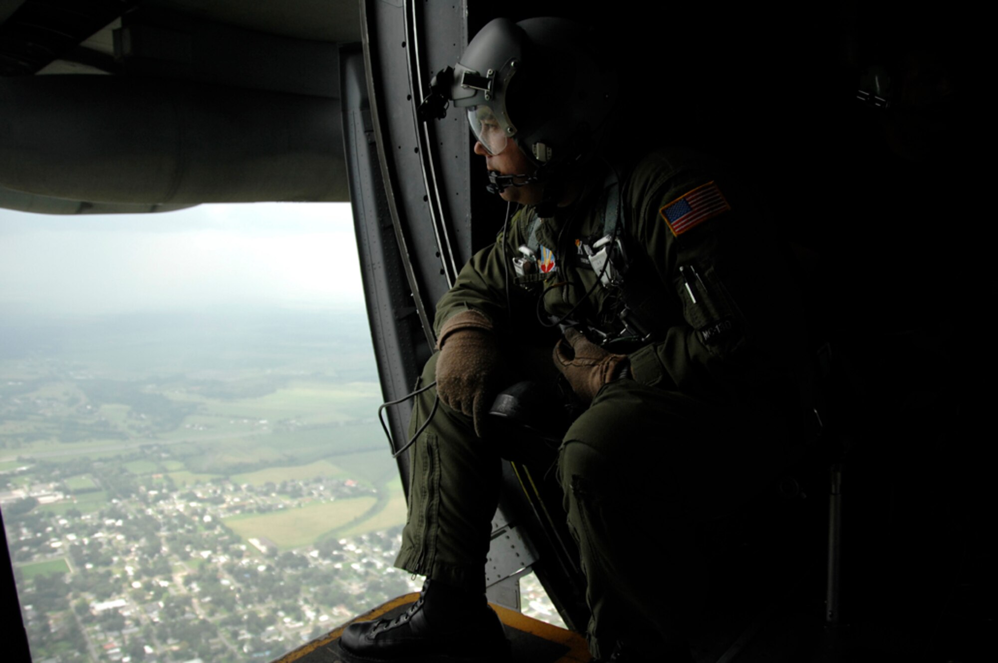 Tech. Sgt. Eric Valdez, 129th Rescue Wing loadmaster, scans the ground in Louisiana for civilian victims in need of rescue Sept. 2.  More than 80 Airmen from the 129th RQW deployed to Ellington Field, Texas, as part of Joint Task Force 129, which supported Hurricane Gustav rescue operations. Air National Guardsmen from the 106th Rescue Wing, Gabreski Airport, N.Y., and 176th Wing, Kulis Air National Guard Base, Alaska, were also part of the rescue task force. (U.S. Air Force photo by Tech. Sgt. Ray Aquino)