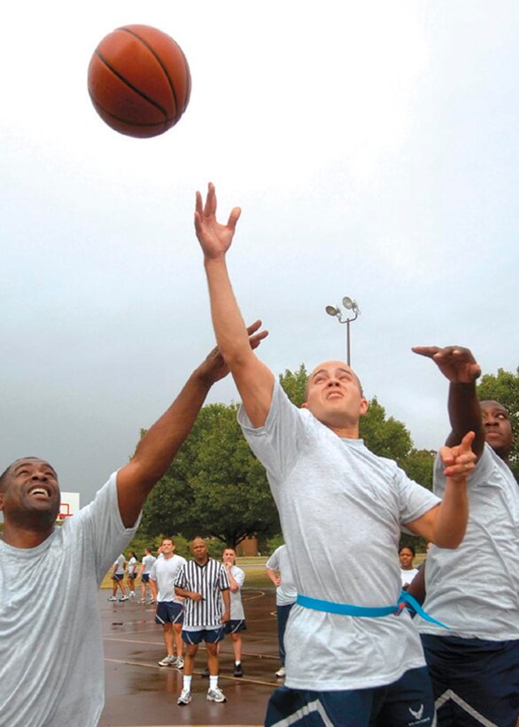An Airmen shoots a two pointer between opponents during a three-on-three basketball tournament Aug. 29. Approximately 700 members from the 79th Medical Wing participated in the day-long athletic event, which consisted of a two-mile walk/run,  the push-up and sit-up contest, softball, basketball, volleyball, tug-of-war and slueshing competitions. The purpose of the event was to foster Esprit de corps among fellow Airmen within the 79th and 579th Medical Groups. (U.S. Air Force photo by Bobby Jones)