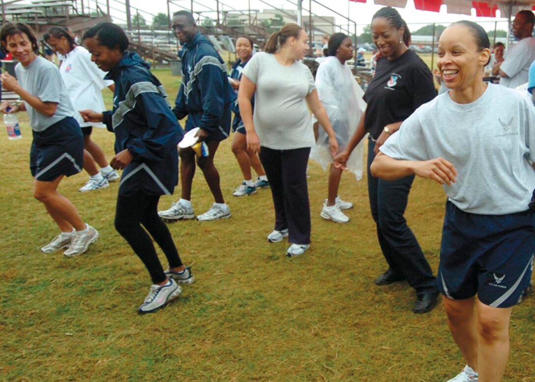 A group of Airmen take a break from the athletic events by joining a line dance Aug. 29. Approximately 700 members from the 79th Medical Wing participated in the day-long athletic event, which consisted of a two-mile walk/run,  the push-up and sit-up contest, softball, basketball, volleyball, tug-of-war and slueshing competitions. The purpose of the event was to foster Esprit de corps among fellow Airmen within the 79th and 579th Medical Groups. (U.S. Air Force photo by Bobby Jones)