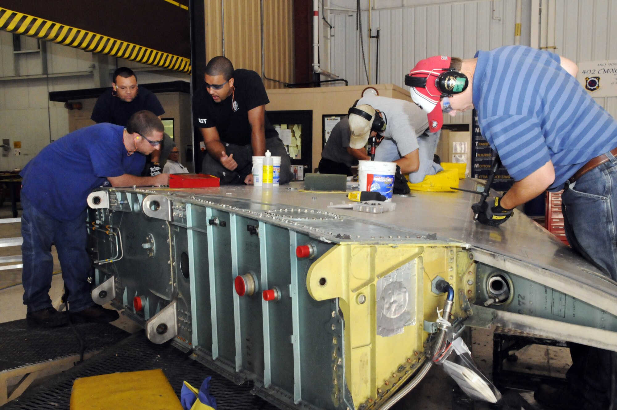Workers in the F-15 wing tear down shop strip a wing down to get it ready for repairs. U. S. Air Force photo by Sue Sapp