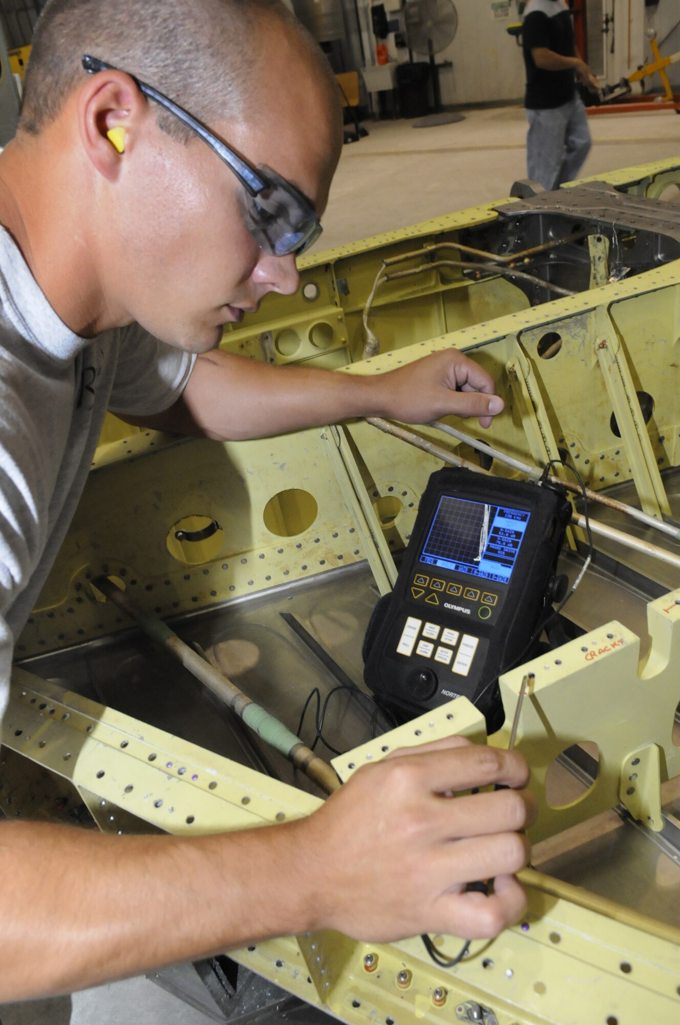 Jason Miller, non-destructive inspector, finds cracks using eddy current.  U. S. Air Force photo by Sue Sapp