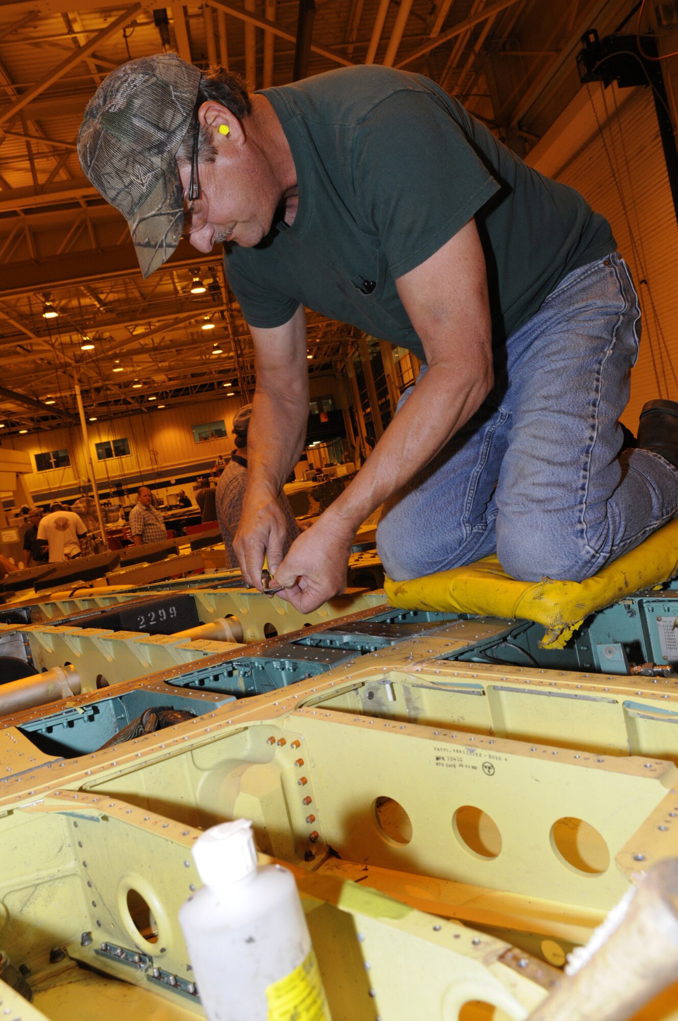 Scott Williams, sheet metal mechanic, installs a bell crank on a flight control. U. S. Air Force photo by Sue Sapp