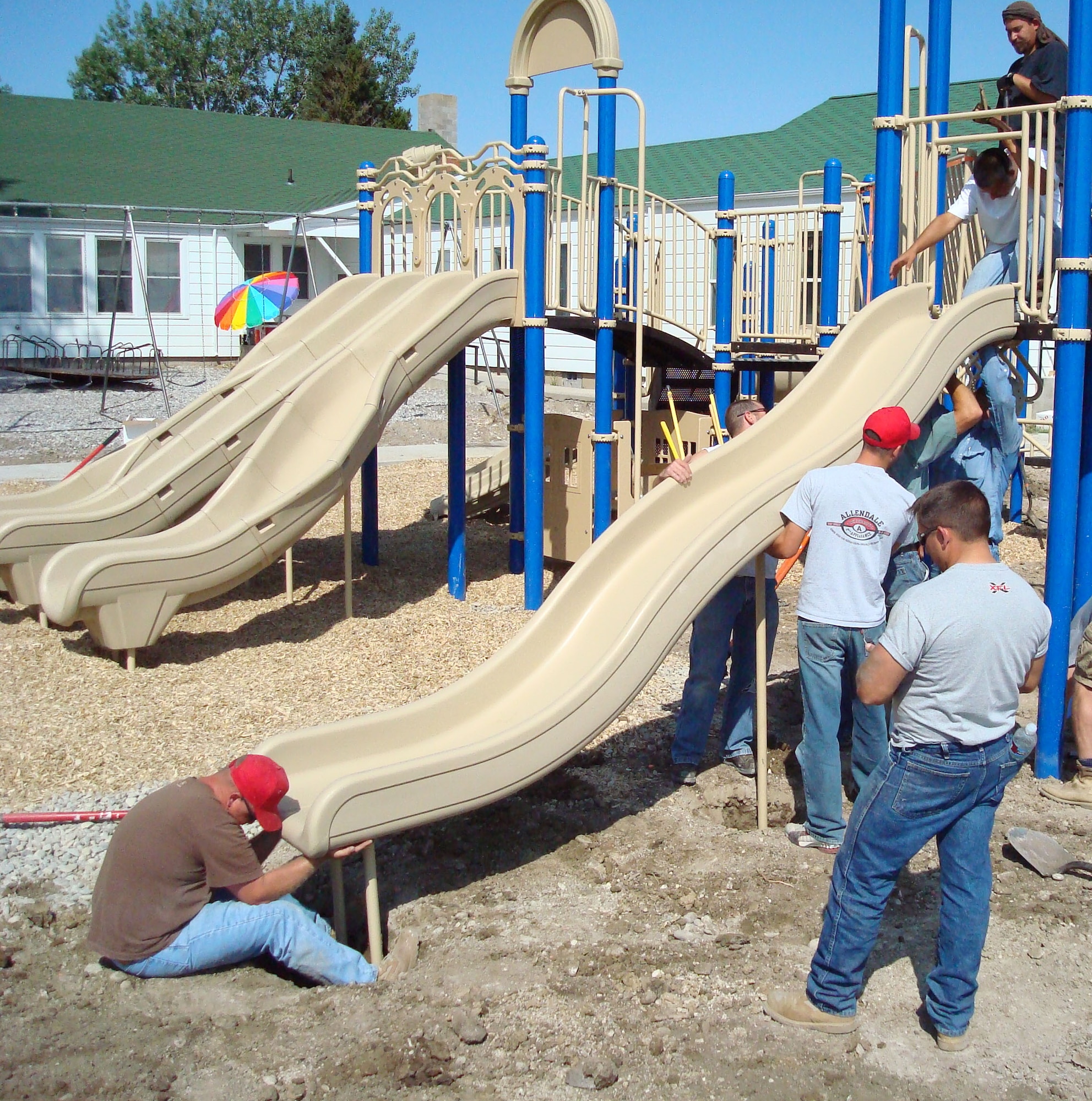 The fourth of five slides on the new playground equipment at the Greenfield School gets installed Aug. 16 by contractors with the help of volunteers from the 819th RED HORSE Squadron. The children of the rural school 13 miles outsdie of Fairfield had been working for five years trying to raise enough money to get a new slide for their playground area. (U.S. Air Force photo/Master Sgt. Larry Lenneman)