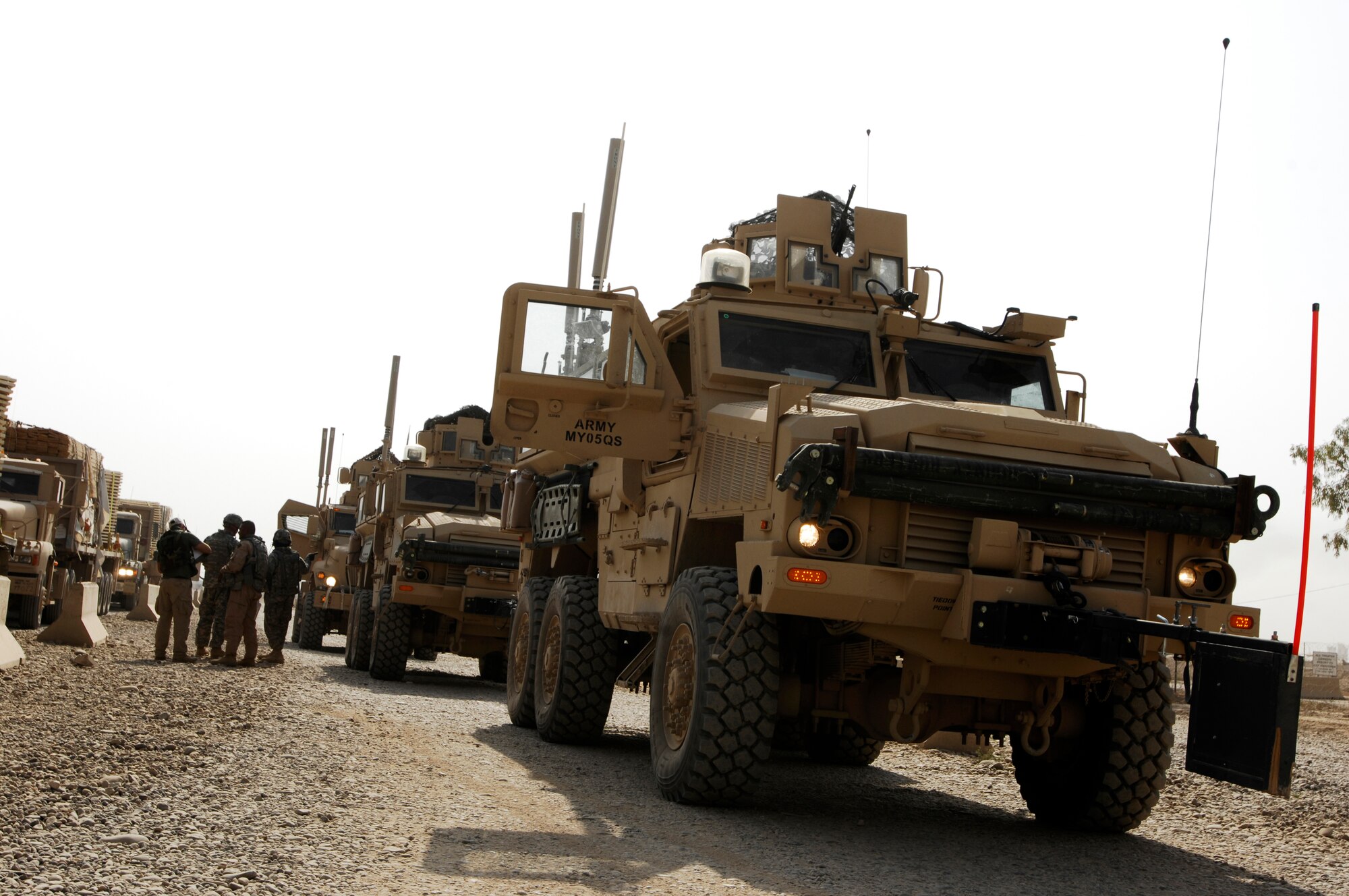 JOINT BASE BALAD, Iraq -- A convoy of mine-resistant ambush-protected vehicles, Humvees and tractor trailers waits at a staging point before convoying outside the wire to a forward operating base Sept. 4. The 732nd Expeditionary Civil Engineer Squadron Utilities Detachment 6 prefabricates as much of its work as possible here before transporting it to the construction site. This maximizes the speed of construction and minimizes time spent outside the wire under threat. The 732nd ECES and other squadrons within the 732nd Air Expeditionary Group here are composed of joint source solution Airmen who fill taskings traditionally performed outside the wire by the Army. (U.S. Air Force photo/Airman 1st Class Jason Epley)