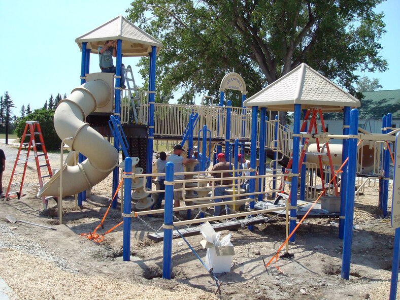 Volunteers from the 819th RED HORSE Squadron work alongside contractors and members of the Greenfield School community work to assemble a new playground Aug. 16 prior to the first day of school. It took the group three days to complete but it was finished in time for the children's return Aug. 21. (U.S. Air Force photo/Master Sgt. Larry Lenneman)