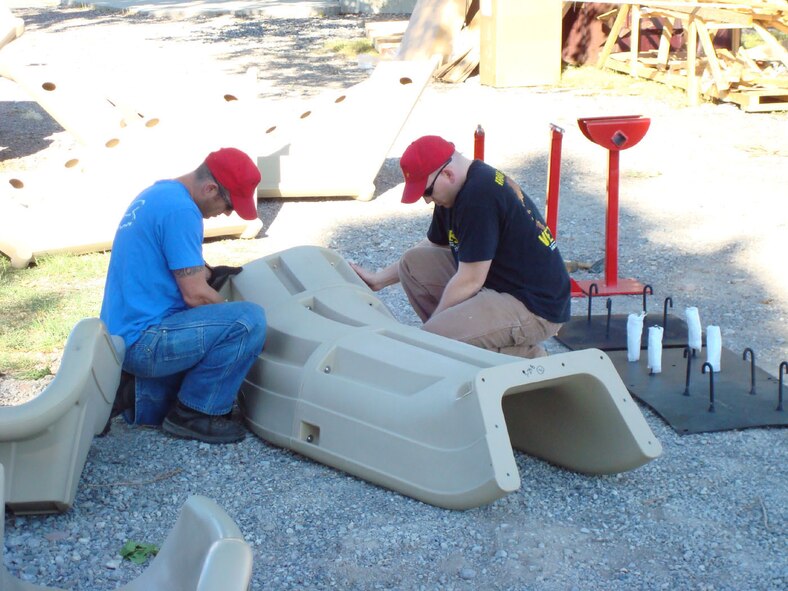 Volunteers from the 819th RED HORSE Squadron at Malmstrom work with contractors from Summit Recreation during the early stages of assembling a multi-faceted playground for the Greenfield School Aug. 15. (U.S. Air Force photo/Master Sgt. Larry Lenneman)