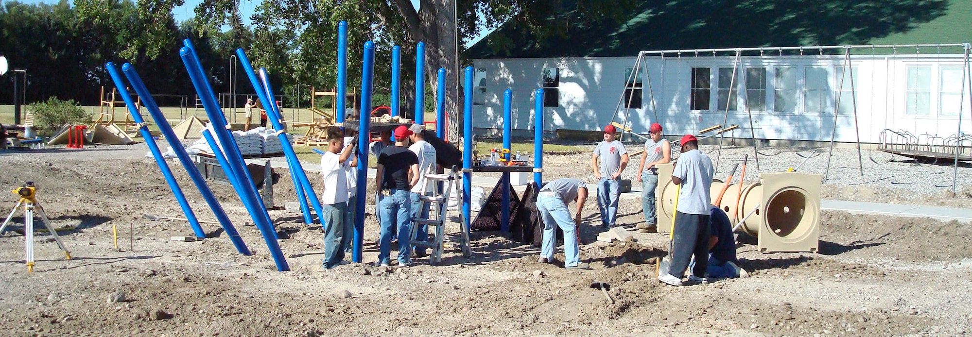 Volunteers from the 819th RED HORSE Squadron at Malmstrom work with contractors from Summit Recreation during the early stages of assembling a multi-faceted playground for the Greenfield School Aug. 15. (U.S. Air Force photo/Master Sgt. Larry Lenneman)
