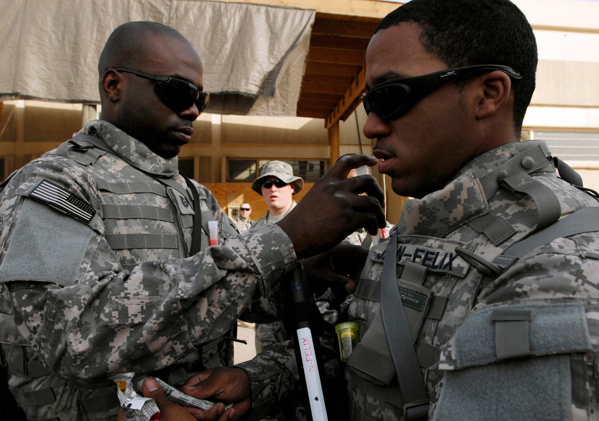 JOINT BASE BALAD, Iraq -- Tech. Sgt. Christopher Downing (left) inserts glow sticks into Staff Sgt. Jean Jean-Felix's body armor here before a convoy operation Sept. 4. Downing, a structural craftsman, and Jean-Felix, an electrical journeyman, are assigned to the 732nd Expeditionary Civil Engineer Squadron Utilities Detachment 6, which will build new facilities at a forward operating base to house approximately 350 Soldiers. Downing is deployed from Elmendrof Air Force Base, Alaska, and his hometown is Charleston, S.C. Jean-Felix is deployed from Yokota Air Base, Japan, and is originally from Orlando, Fla. (U.S. Air Force photo/Airman 1st Class Jason Epley)