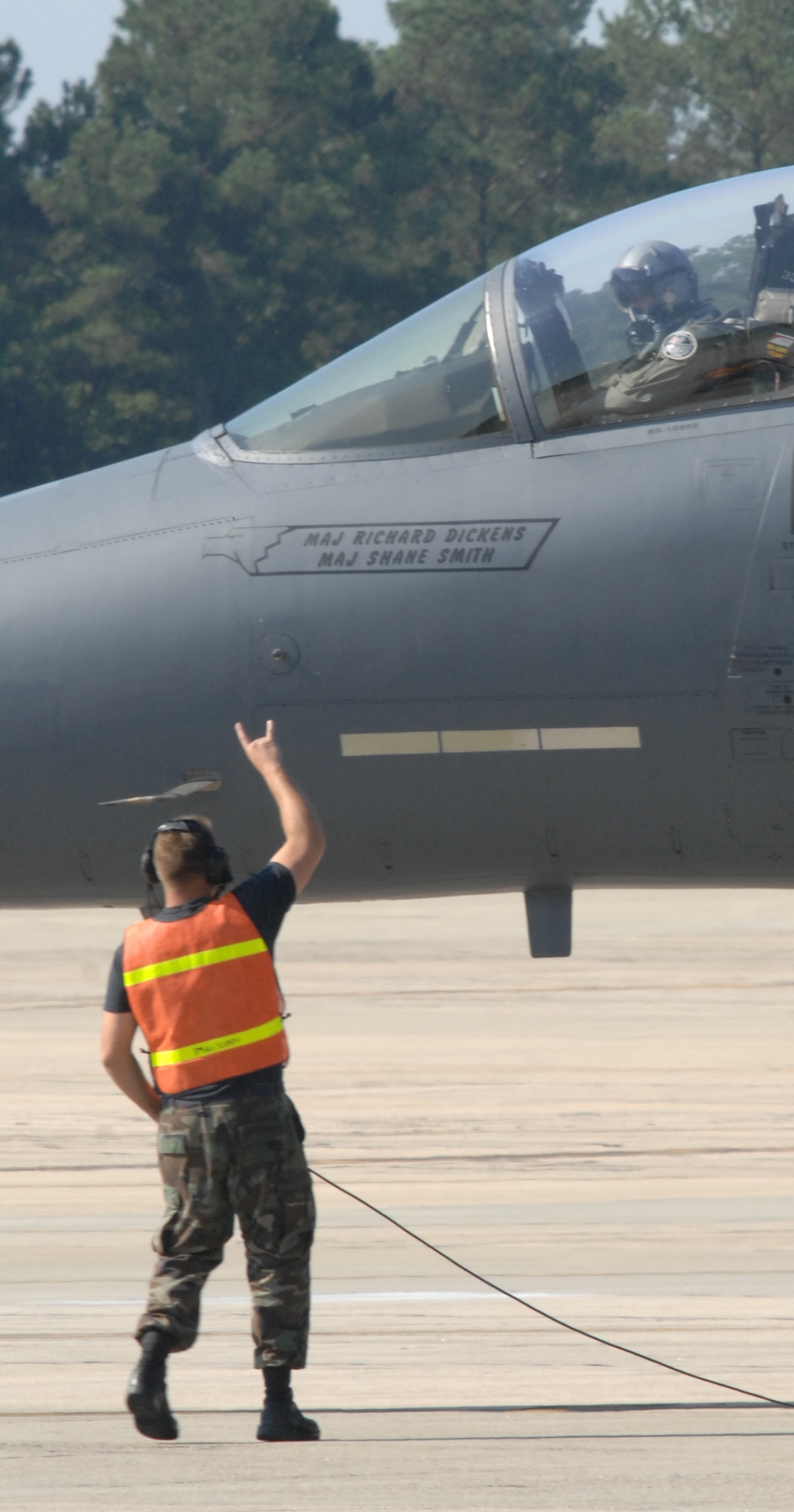 A crew chief here at Seymour Johnson Air Force Base, gives the pilots of an F-15E Strike Eagle the ?Rock On? sign as they taxi to the runway while evacuating aircraft August 4th, 2008.  Approximately 80 Strike Eagles and 3 KC-135 Stratotankers are being evacuated to Wright Patterson Air Force Base in Dayton, Ohio to ride out Hurricanes? Hannah and Ike. (U.S. Air Force Photo by Airman 1st Class Rae Henline)