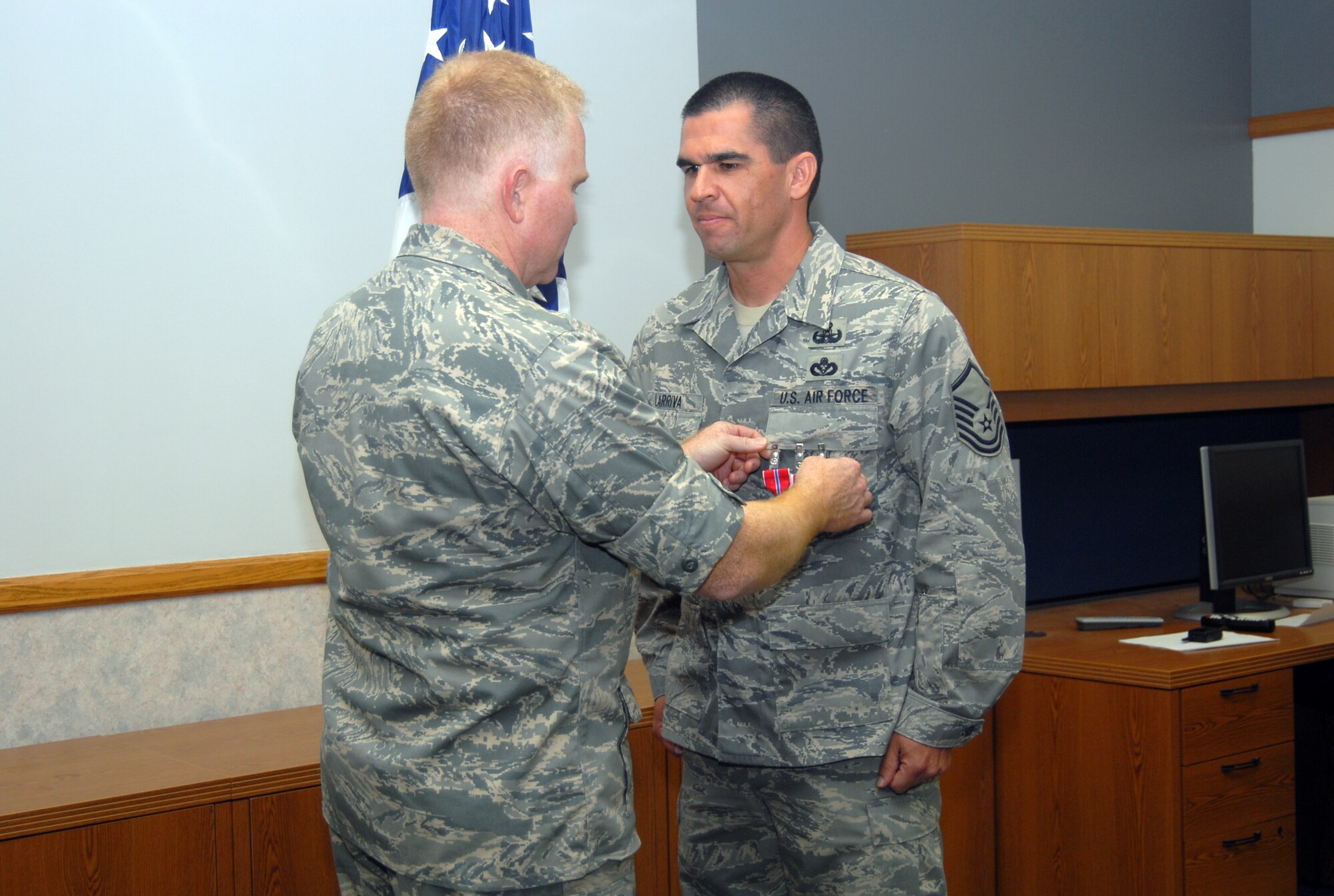 Master Sgt. David Larriva (right), 95th Civil Engineering and Transportation Directorate Explosive Ordnance Division superintendent, receives his second Bronze Star Medal, a Meritorious Service Medal and an Air Force Combat Action Medal during a ceremony at the CE Conference Center Aug. 27. Col. Jerry Gandy (left), 95th Air Base Wing commander, presented the awards to Sergeant Larriva. (Air Force photo by Senior Airman Julius Delos Reyes)