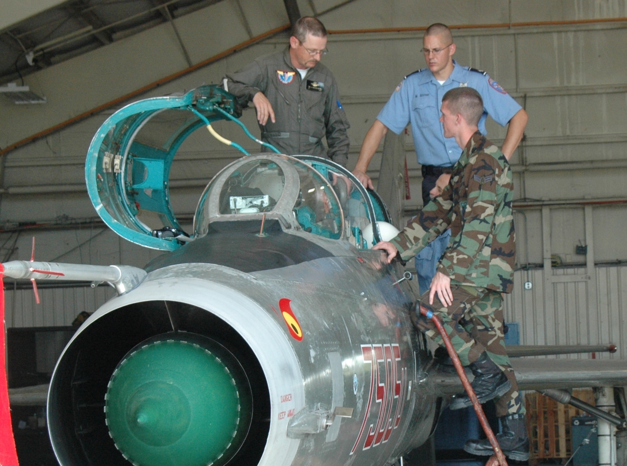 Van Den Heuvel describes the capabilities of his MiG 21 to Eglin firefighters Michael Glover and A1C David Jeghers. The jet was used for 33d FW training exercises Aug. 27 and 28. During its down time, the hangar was open for anyone who wanted to see the jet.