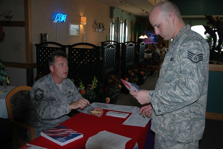 Staff Sgt. Christopher Clark gets information on registering to vote from Senior Master Sgt. Jeffrey Hebner at the Riverside Dining Facility September 2 during Armed Forces Voting Week. Tables were set up today in the Dining Facility and other public areas, such as the Base Exchange, where troops could find out about how to receive absentee ballots from unit Voting Assistance Officers. (U.S. Air Force photo by Airman 1st Class David Dobrydney)