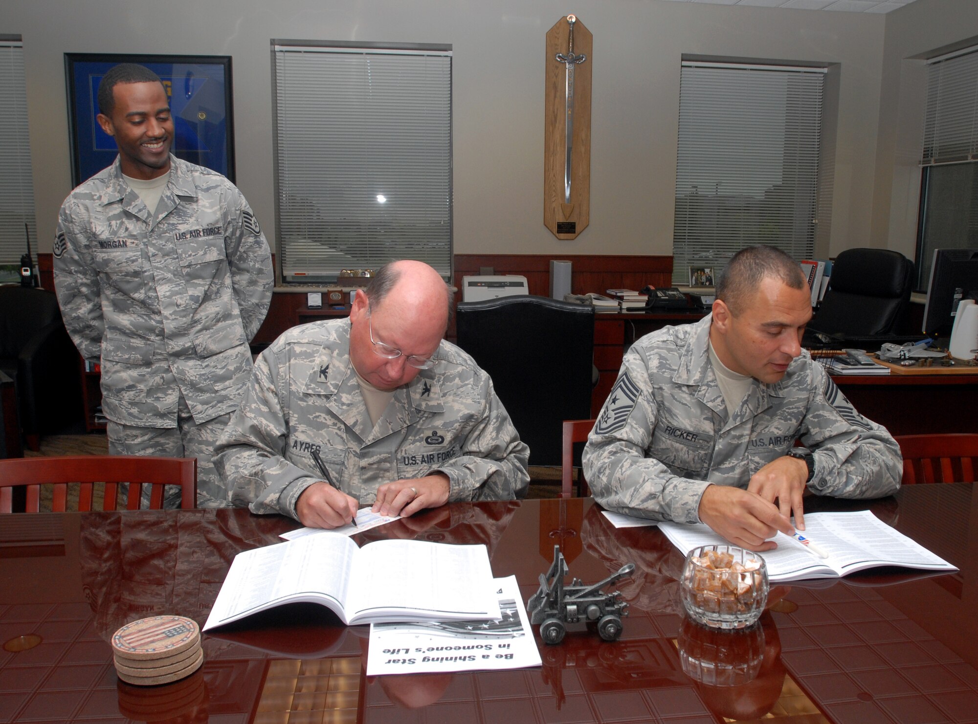 Colonel Richard Ayres (center), 17th Training Wing commander, and Chief Master Sgt. Frederick Ricker (right), 17 TRW command chief master sergeant, sign up for the 2008 Combined Federal Campaign with the help of Staff Sgt. Christopher Morgan, a campaign volunteer. (U.S. Air Force photo by Paul Martin)