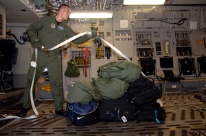 Airman 1st Class Kyle Simpson straps down luggage for the aircrew who are leaving on a C-17 that evacuated Charleston AFB Sept. 4. In preparation for possible hurricane conditions, the base evacuated aircraft, flight crews and maintenance technicians to Whiteman AFB, Mo., and Wright-Patterson AFB, Ohio. Airman Simpson is a loadmaster with the 17th Airlift Squadron.  (U.S. Air Force photo/Airman 1st Class Cynthia Spalding)