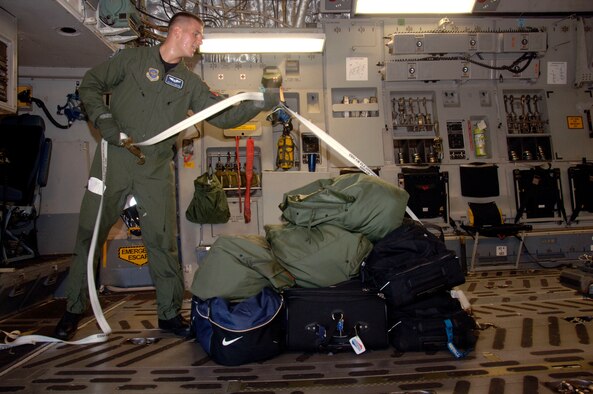 Airman 1st Class Kyle Simpson straps down luggage for the aircrew who are leaving on a C-17 that evacuated Charleston AFB Sept. 4. In preparation for possible hurricane conditions from the approaching Tropical Storm Hanna, the base evacuated aircraft, flight crews and maintenance technicians to Whiteman AFB, Mo., and Wright-Patterson AFB, Ohio. Airman Simpson is a loadmaster with the 17th Airlift Squadron. (U.S. Air Force photo/Airman 1st Class Cynthia Spalding) 
