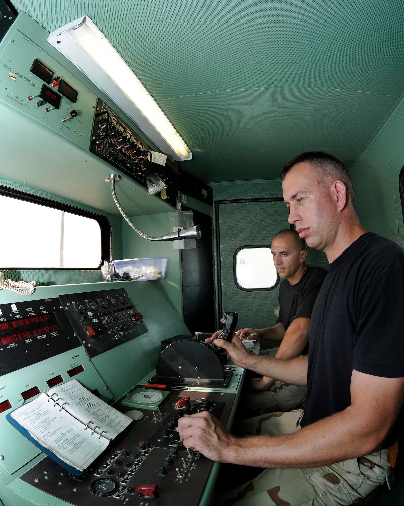 Tech. Sgt. Gregory Mathes, 379th Expeditionary Maintenance Squadron, performs initial engine operations test steps in the control booth as Senior Airman Beau Columbus, 379 EMXS, watches and records each step Sept. 3, 2008, at an undisclosed air base in Southwest Asia.  Sergeant Mathes will give the C-130 Hercules engine a good stressful run through during operations and propeller leak checks. The C-130 Hercules primarily performs the tactical portion of the airlift mission. The aircraft is capable of operating from rough, dirt strips and is the prime transport for air dropping troops and equipment into hostile areas.  Sergeant Mathes, a native of Greenville, Tenn., is deployed from Ramstein Air Force Base, Germany and Airman Columbus, originally from Buffalo, N.Y., is deployed from Yokota Air Base, Japan.  Both are supporting Operations Iraqi and Enduring Freedom and Joint Task Force-Horn of Africa. (U. S. Air Force photo by Tech. Sgt. Michael Boquette/Released)