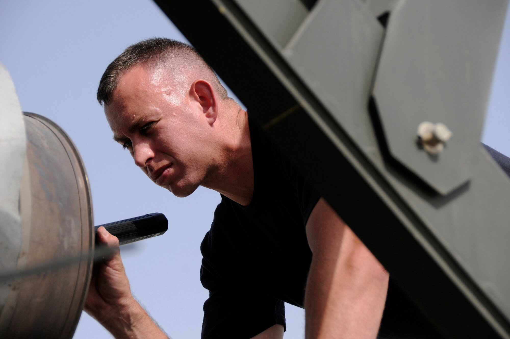 Tech. Sgt. Gregory Mathes, 379th Expeditionary Maintenance Squadron, checks the exhaust port prior to an engine operations test Sept. 3, 2008, at an undisclosed air base in Southwest Asia.  Checking for loose fan blades is one of the steps to get this C-130 Hercules engine back in operation.  The C-130 Hercules primarily performs the tactical portion of the airlift mission. The aircraft is capable of operating from rough, dirt strips and is the prime transport for air dropping troops and equipment into hostile areas.  Sergeant Mathes, a native of Greeneville, Tenn., is deployed from Ramstein Air Base, Germany, supporting Operations Iraqi and Enduring Freedom and Joint Task Force-Horn of Africa.  (U.S. Air Force photo by Tech. Sgt. Michael Boquette/Released)