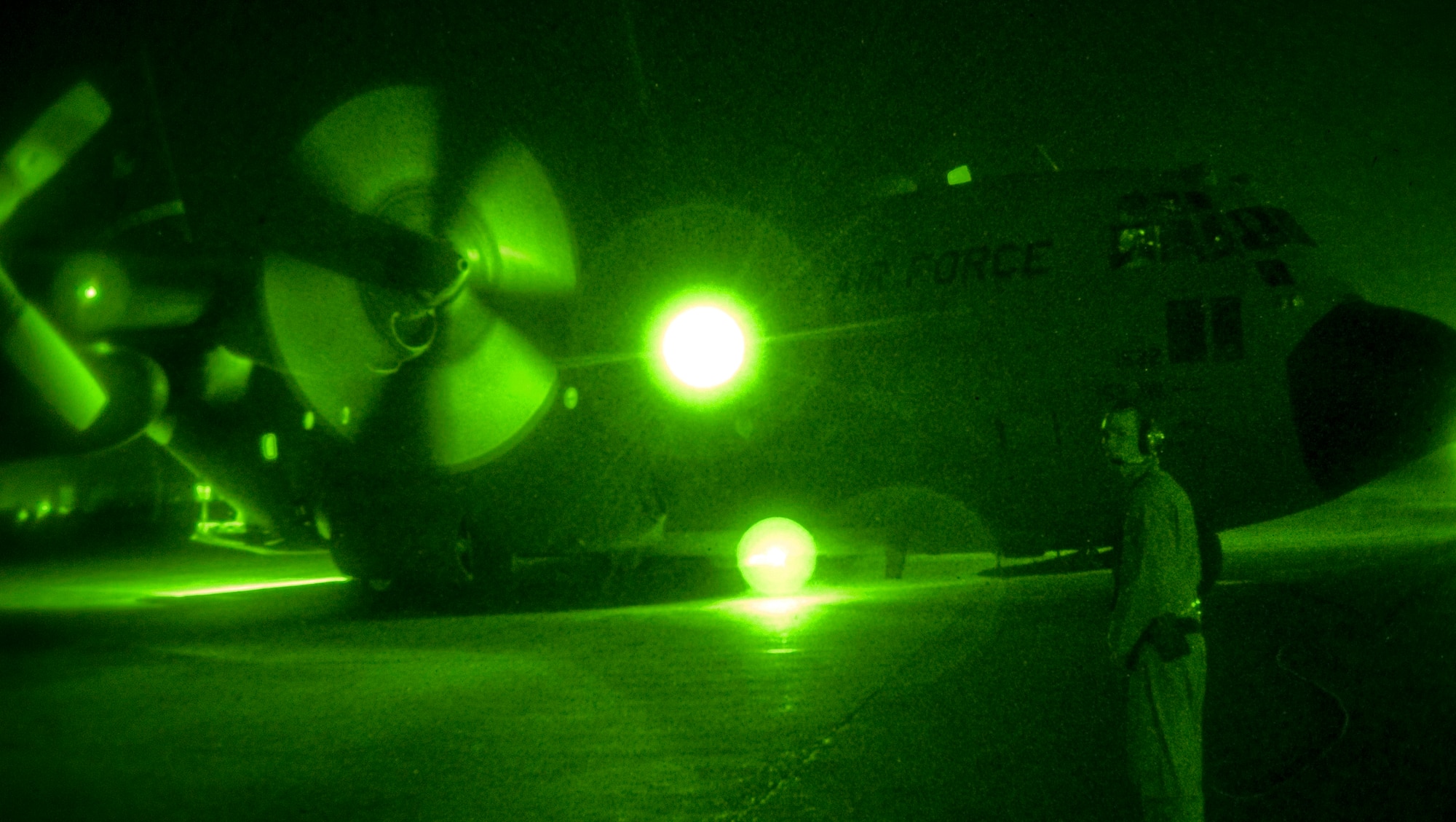 BAGHDAD INTERNATIONAL AIRPORT, Iraq -- Airman 1st Class Delmar Karnes, a loadmaster with the 777th Expeditionary Airlift Squadron, observes the startup of a C-130 Hercules' engines here in the early morning of Sept. 3. Karnes, who is deployed from Little Rock Air Force Base, Ark., was part of the aircrew that flew the 777th EAS' 25,000th combat sortie since beginning operations at Joint Base Balad in February 2006. (U.S. Air Force photo/Tech Sgt. Erik Gudmundson)
