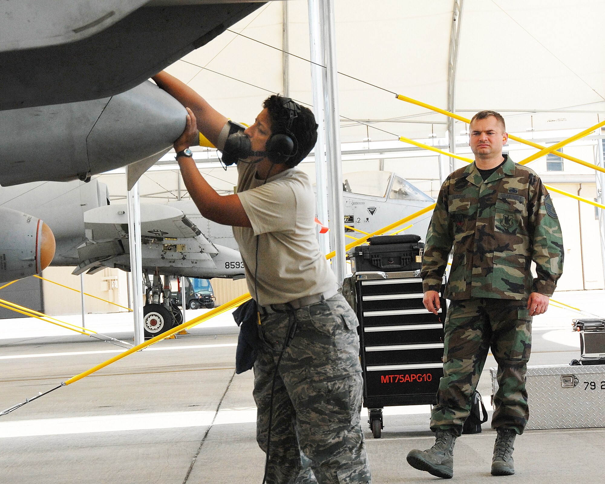 Senior Airman Tracey Robson; an Air Force reservist assigned to the 442nd Fighter Wing; Detachment 1; opens an aircraft access panel under the watchful eye of active-duty supervisor; Master Sgt. James Perdue; 23rd Aircraft Maintenance Squadron; at Moody Air Force Base; Ga. Airman Robson is one of several Air Force reservists at Moody laying the groundwork for an Air Force Reserve Command A-10 associate fighter group that will be teamed up with Moody's active-duty 23rd FG. The 23rd FG's parent organization; the 23rd Wing; traces its Air Force roots to the legendary Flying Tigers of World War II. Detachment 1 will become the 476th FG and it will share that lineage. The detachment is a geographically separated unit of the 442nd FW; an AFRC A-10 wing at Whiteman AFB; Mo. (US Air Force photo/Master Sgt. Bill Huntington)