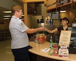 Danielle Jaruez hands Tech. Sgt. Allison Cademartori, 37th Contracting Squadron, her morning coffee at the Green Beans coffee shop. (USAF photo by Alan Boedeker) 