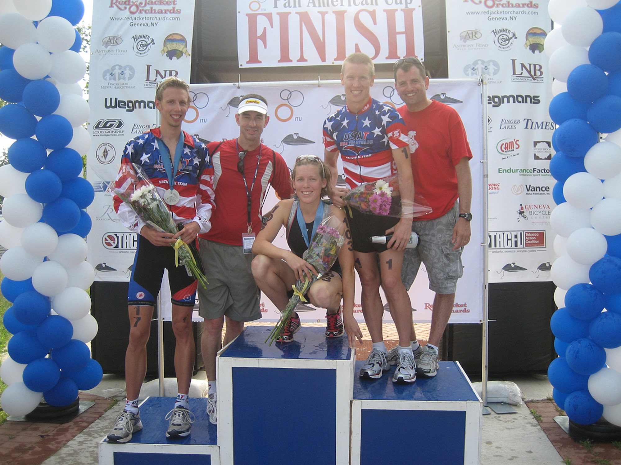 GENEVA, N.Y. -- Rich Axtell, far right, poses with, from left, Ethan Brown, Tim Crowley, Alicia Kaye and Jarrod Shoemaker following the Musselman Pan American Cup Triathlon. Mr. Axtell is the swim coach while Mr. Crowley is the bike and run coach for triathletes Brown, Kaye and Shoemaker, all of whom are members of Minuteman Masters Swim Club. In addition to coaching the Minuteman Masters Swim Club, Mr. Axtell is a trainee in the Electronic Systems Center's developmental program currently working as a contract specialist in the 66th Contracting Squadron. One of the members of the club, Mr. Shoemaker, competed in the 2008 Olympics. (U.S. Air Force photo)