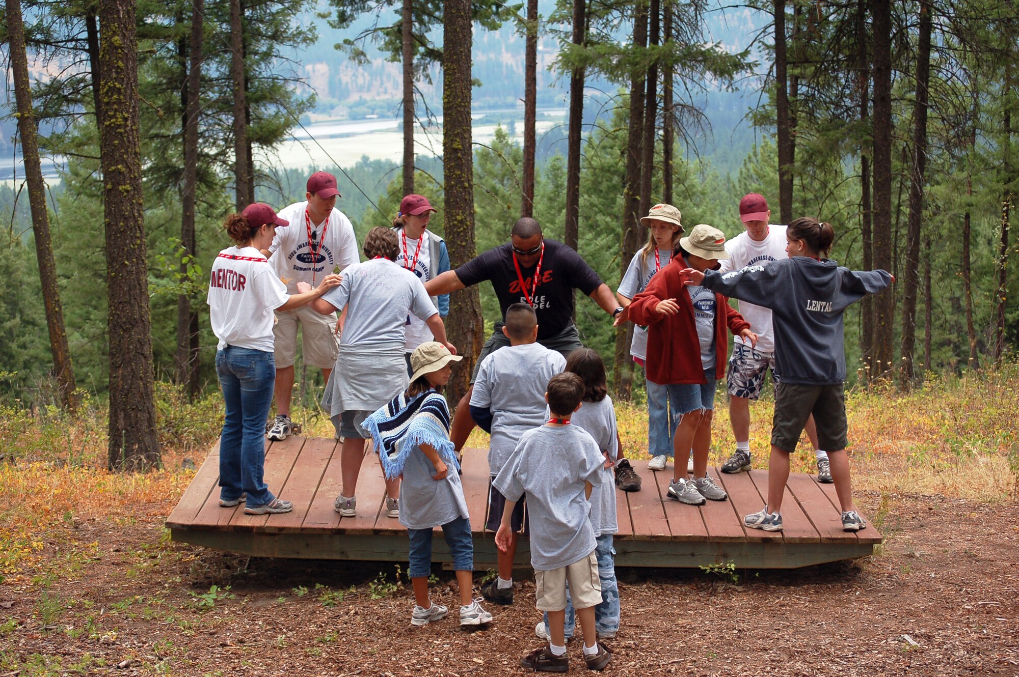 NINE MILE FALLS, Wash. – Master Sgt. Edward Tillman, 92nd Security Forces Squadron, leads a group in a team-building balance exercise Aug. 22. The children attended a week-long camp participating in various events which focused on leadership, overcoming fears and self- confidence. The camp was geared to aid children with the tools to make better choices in everyday life when faced with adversity. (U.S. Air Force photo / Staff Sgt. JT May III)
