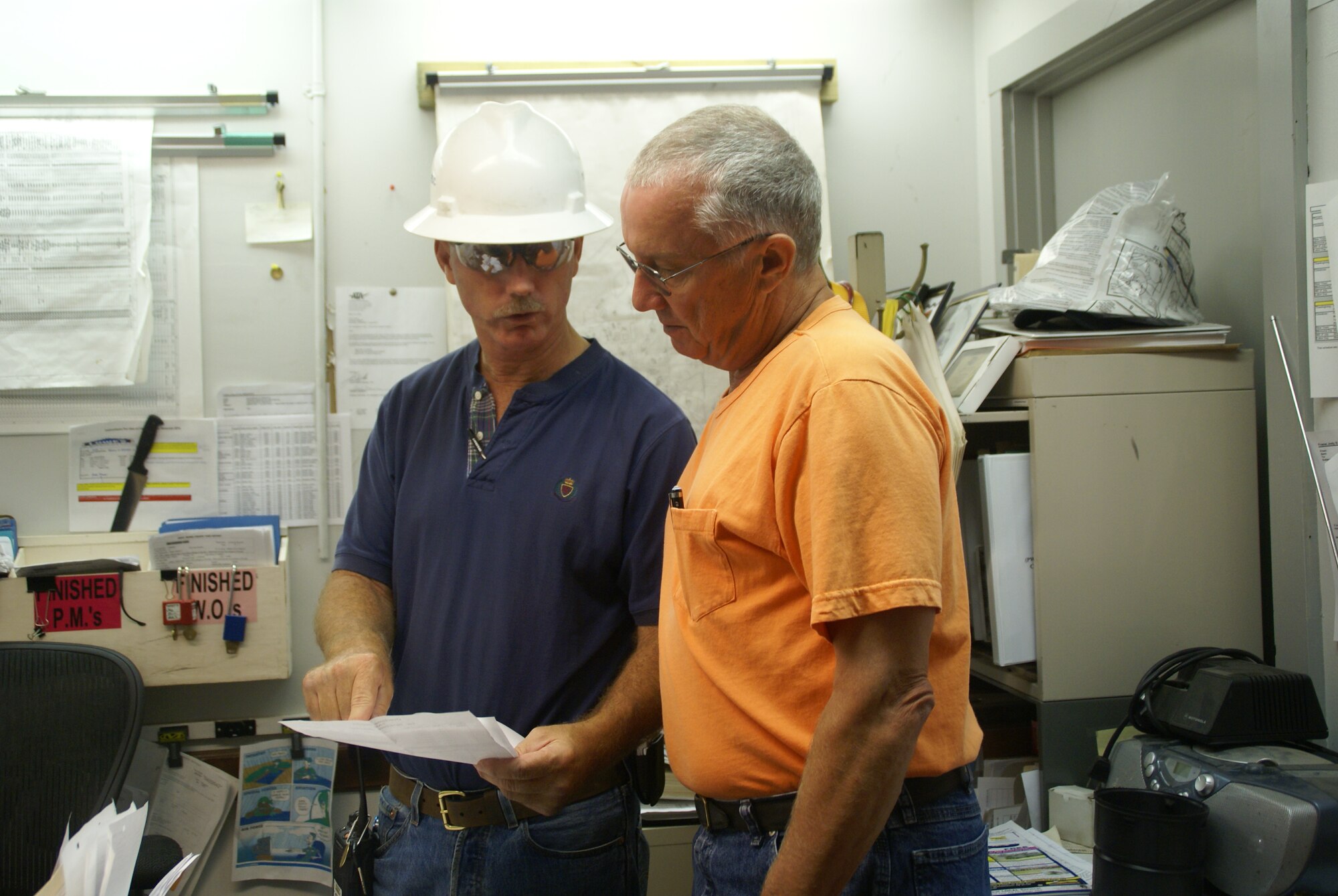 Jody Frame (left), ATA supervisor for utility maintenance (except electricity) at Arnold, reviews a maintenance work schedule with Butch Langford, a heating, ventilation and air conditioning technician. (Photo by Philip Lorenz III)