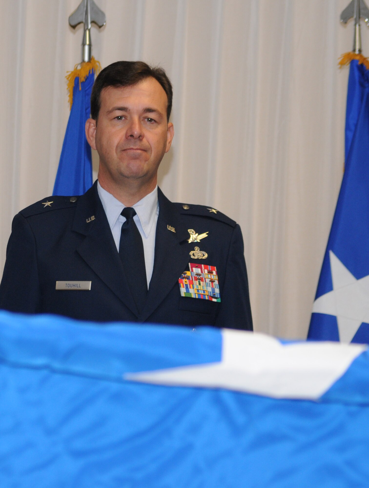 A proud Brig. Gen. Greg Touhill, 81st Training Wing commander, watches intently as a one-star flag is unrolled in his honor at his formal "pin on" ceremony.  The event was presided over by Maj. Gen. Al Flowers, 2nd Air Force commander.  General Touhill's official date of rank is September 2, but the large, formal ceremony was pushed back to September 5 due to the negative weather associated with Hurricane Gustav. (U.S. Air Force photo by Kemberly Groue)