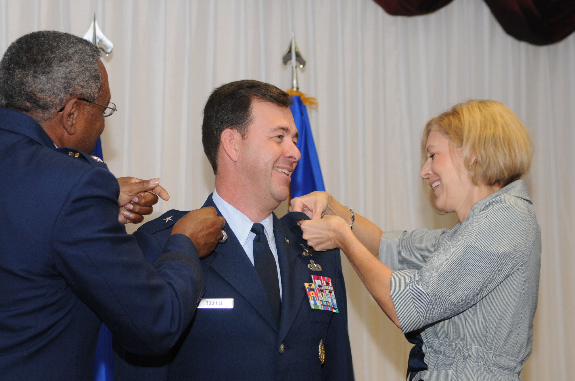 Maj. Gen. Al Flowers, 2nd Air Force commander, and Mrs. Charlene Touhill "pin on" rank to newly promoted Brig. Gen. Greg Touhill, 81st Training Wing commander.  General Touhill's official date of rank is September 2, but the large, formal ceremony was pushed back to September 5 due to the negative weather associated with Hurricane Gustav.  (U.S. Air Force photo by Kemberly Groue)