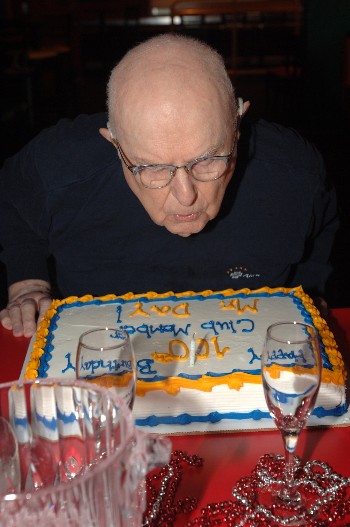 Retired Navy Lt. Cmdr. Richmond Day blows out the candle on his birthday cake during a celebration of his 100th birthday at Grand Forks Air Force Base Sep. 4. The retired Navy officer, who served the country for 20 years, starting at Pearl Harbor in 1943, was surrounded by friends and family as well as Airmen from the base for the celebration. (U.S. Air Force photo/Tech. Sgt. Joseph Kapinos)