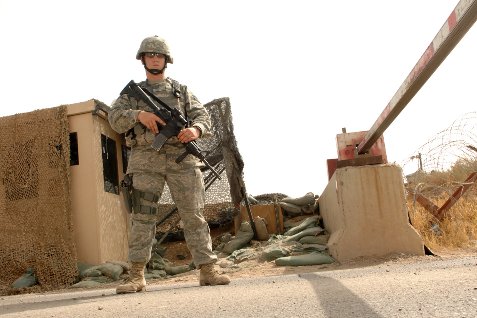 KIRKUK REGIONAL AIR BASE, Iraq -- SrA Benjamin Hathaway, 506th Expeditionary Security Forces Squadron fire team member, poses in front of a gate here August 7.  SrA Hathaway is the son of Tech Sgt. Kelly Beeler and nephew of Tech. Sgt. Kimberly McBride, 506 ESFS.  The three are deployed here together from Maxwell Air Force Base, Ala., and Schriever AFB, Colo. (U.S. Air Force photo/Senior Airman Randi Flaugh)