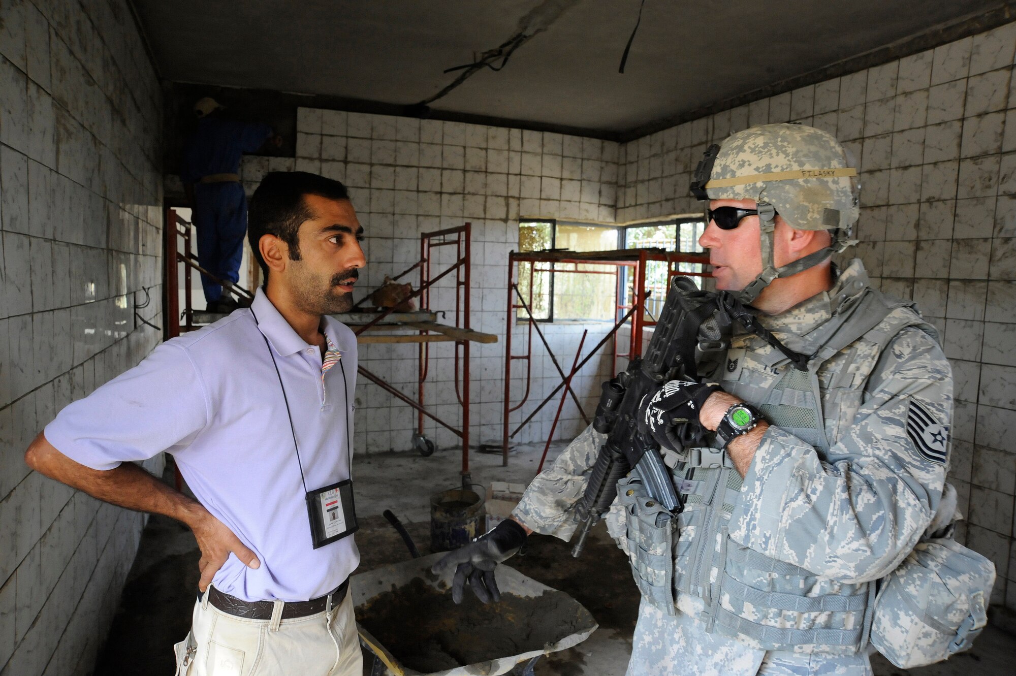 HAWR RAJAB, IRAQ -- U.S. Air Force Tech. Sgt. Jason Filasky, right, contracting representative with the 557th Expeditionary RED HORSE squadron, talks with a contractor about the tile being used for a battled damaged home in the city of Hawr Rajab, Iraq on Aug. 27. Filasky, a Middletown, Del. native, is deployed from 823rd RED HORSE squadron, Tyndall Air Force Base, Fla. (U.S. Air Force photo/Staff Sgt. Paul Villanueva II)