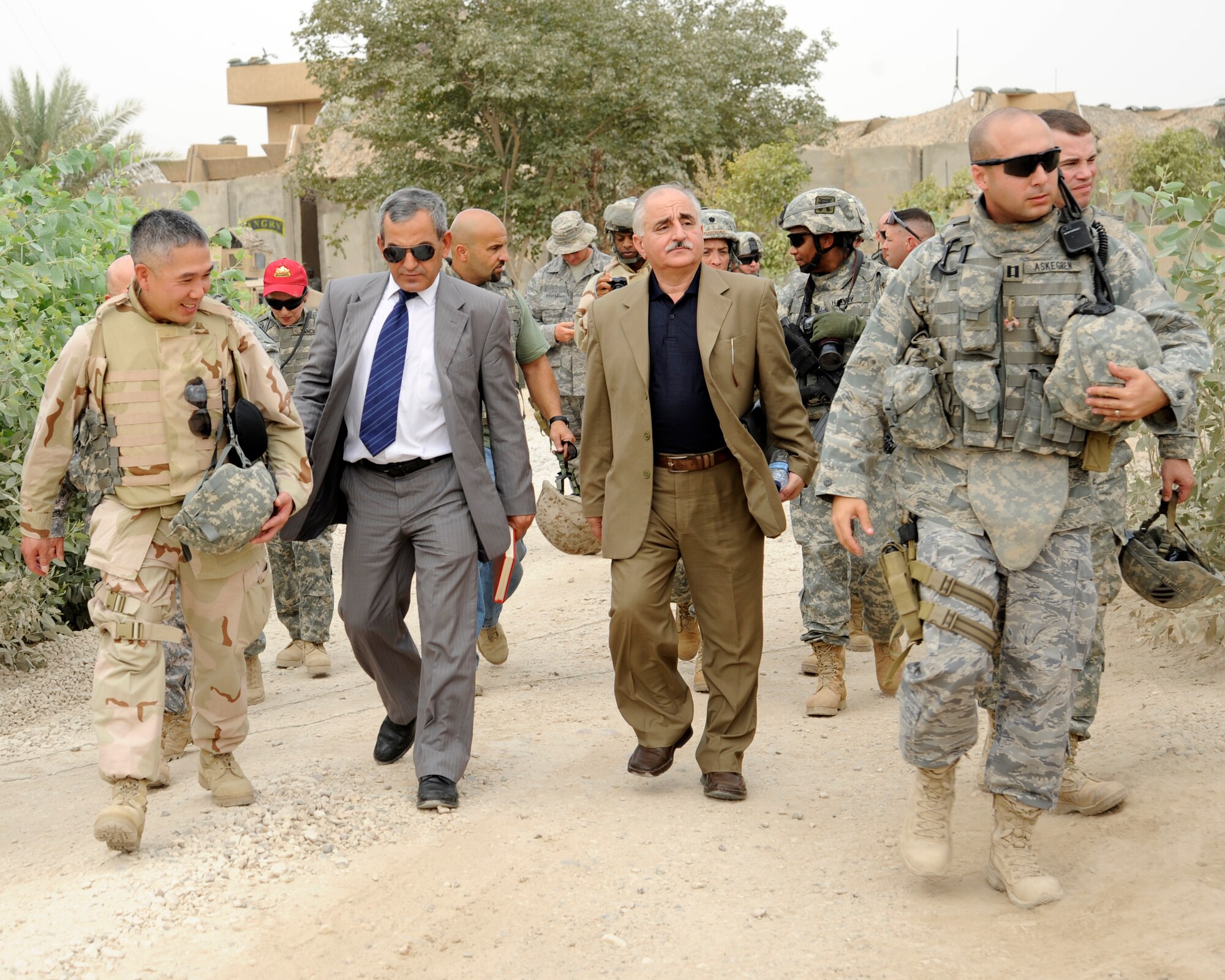HAWR RAJAB, IRAQ -- L-R, U.S. Navy Capt. Brandon Chang, Multi-National Forces-Iraq CJ9, with Government of Iraq officials Khalid Shiltagh, head of Provincial Reconstruction and Husaiyn Mazid Husaiyn, right, Minister of Construction Housing, and U.S. Air Force Capt. Michael Askegren, Patrol Base Stone site officer in charge, walk to the Village of Hope school at Hawr Rajab, Iraq on Aug. 25. (U.S. Air Force photo/Staff Sgt. Paul Villanueva II)