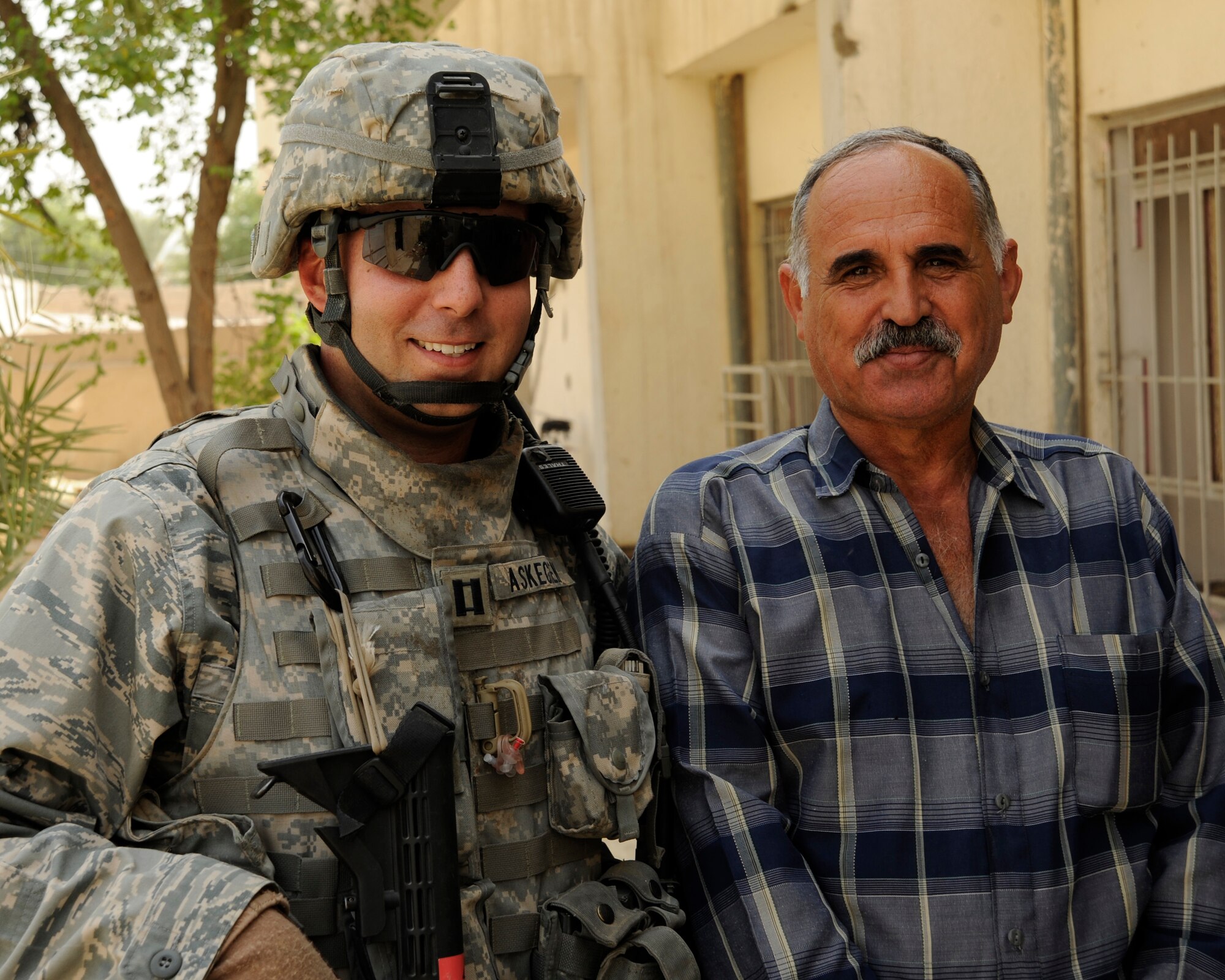 HAWR RAJAB, IRAQ -- U.S. Air Force Capt. Michael Askegren, Patrol Base Stone site officer in charge, left, poses for a photo with Hatam, city council reconstruction chairman, at the Al Ma'ang Boys School in the city of Hawr Rajab, Iraq on Aug. 24. Askegren, a Mandeville, La. native, is deployed from the 823rd RED HORSE squadron, Hurlburt Field, Fla. where he is a project engineer. (U.S. Air Force photo/Staff Sgt. Paul Villanueva II)