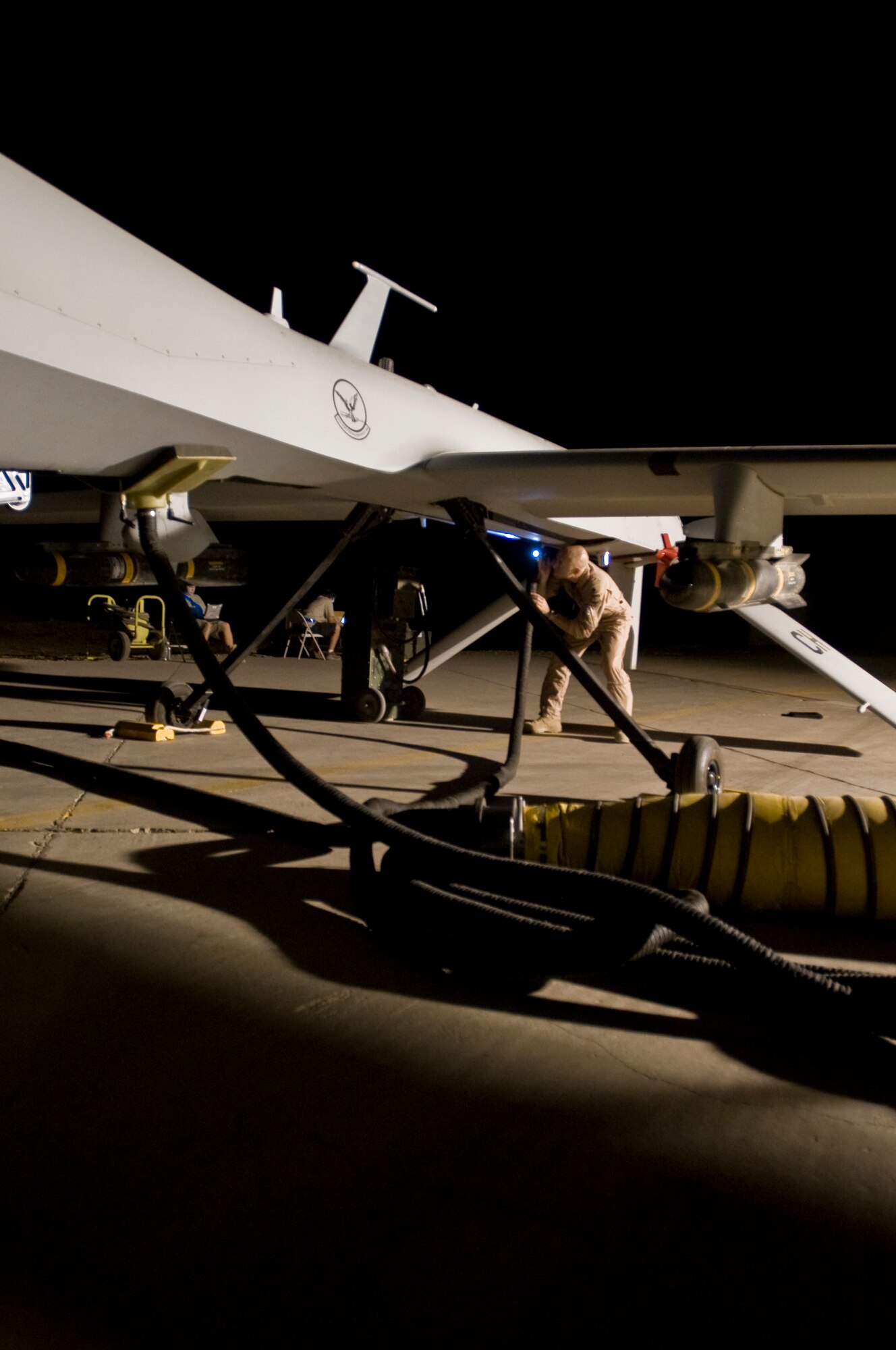 ALI BASE, Iraq - Lt. Col. Geoffrey Barnes, Detachment 1 46th Expeditionary Reconnaissance Attack Squadron commander, performs a pre-flight inspection of an MQ-1B Predator unmanned aerial system Sept. 3, 2008. The Predator is a medium-altitude, long-endurance, remotely piloted aircraft. Its mission here is to interdict and conduct armed reconnaissance against critical and perishable targets in support of the Global War on Terrorism. Barnes is deployed from Creech Air Force Base, Nev. (U.S. Air Force photo/Airman 1st Class Christopher Griffin)