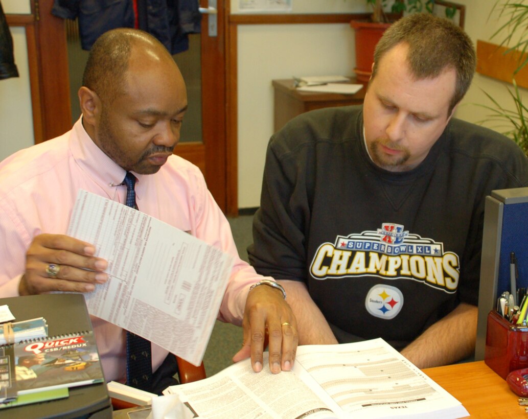 Ron Holland (left) of the U.S. Army Garrison Schinnen, Netherlands, Voting Assistance Office, helps Mike Rhodes complete his voter registration card in time to meet absentee voter deadlines. U.S. Army photo by Sarah J. Schmidt

