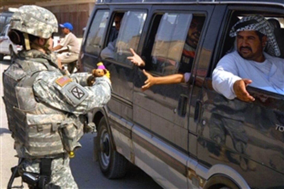 U.S. Army Sgt. Haff hands out stuffed animals to an Iraqi family driving by during a routine visit to the Shlahiya Iraqi Police Station in Shlahiya, Iraq, Sept. 3, 2008. The soldiers are assigned to 16th Military Police Brigade, 511th Military Police Company, 2nd Squad Renegades. 
