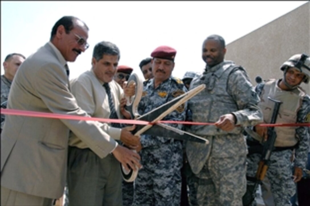 Representatives from the Iraqi 9-Nissan Political District, the U.S. Army Corps of Engineers  and the Iraqi National Police join together to cut the ribbon officially opening the new sewage network pumping station in Kamaliyah, eastern Baghdad, Sept. 3, 2008. The station's network of 12 sub stations will pump up to 50,000 cubic meters, 1.3 million gallons of sewage from two major urban areas.