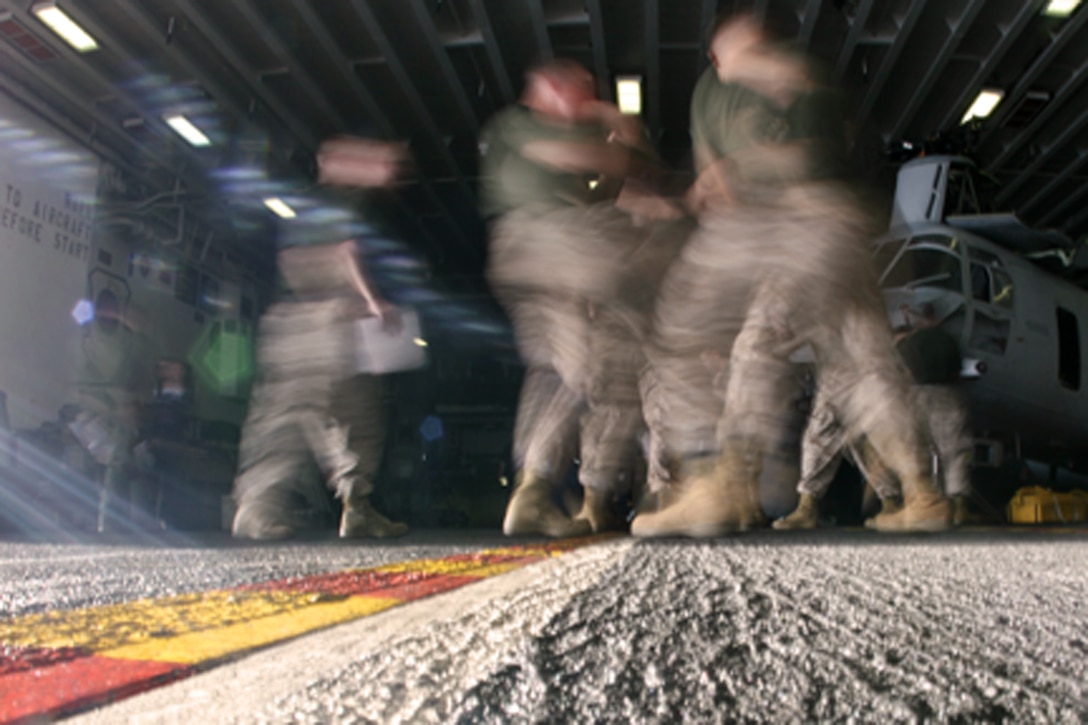 Marines with Battalion Landing Team 2/5, 15th Marine Expeditionary Unit, practice hand-to-hand combat techniques during the grey belt Marine Corps Martial Arts class in the hangar bay of USS Peleliu (LHA 5).::r::::n::   Marine Corps Martial Arts teaches basic hand-to-hand combat techniques as an alternative to the use of conventional weapons. The techniques are especially useful in crowd control and individual detainment to lower threat levels in dangerous or highly charged situations.::r::::n::   The qualified MCMAP instructors of the 15th MEU are working at making each Marine at least a grey belt by the end of fiscal year 2008, per Marine Corps order.::r::::n::   The Camp Pendleton, Calif. based 15th MEU is comprised of approximately 2,200 Marines and Sailors and is a forward deployed force of readiness capable of conducting numerous operations, such as Non-Combatant Evacuation Operations, Humanitarian Assistance Operations and a wide range of amphibious missions. ::r::::n::   The 15th MEU is currently deployed in the Persian Gulf region. (Official USMC photo by Cpl. Timothy T. Parish) (Released)::r::::n::