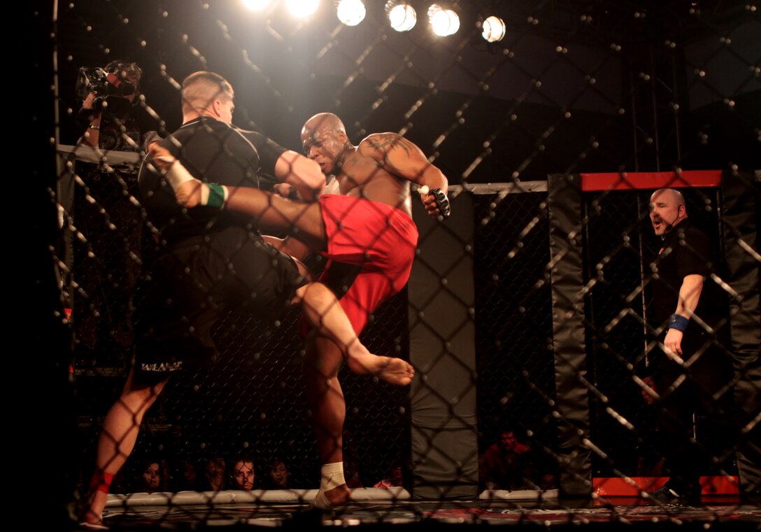 Cole Jones (left), Camp Pendleton Mixed Martial Arts team member, attempts to block a kick from Omar B. Askew, Twentynine Palms MMA team member, during the heavyweight bout of the Armed Forces Championship Fight Series at Camp Pendleton’s Paige Fieldhouse, March 6. All branches of the U.S. military were represented by service members competing in the event that ended with an overall victory by the Camp Pendleton team.