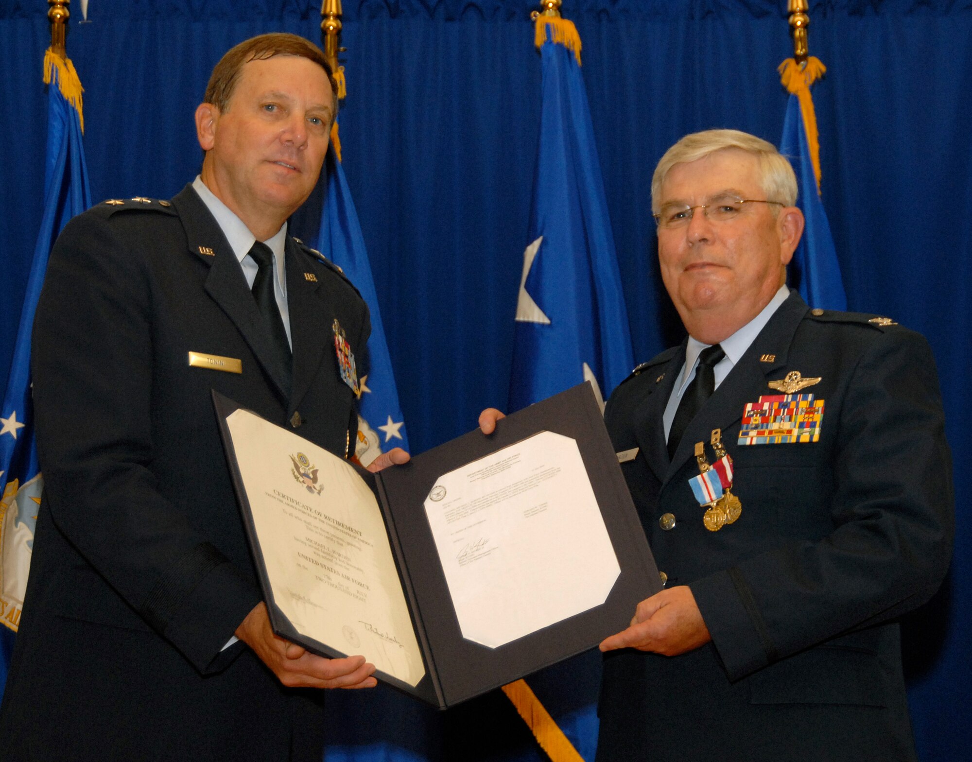 Kentucky’s adjutant general, Maj. Gen. Edward Tonini, presents Col. Michael Harden with a certificate of retirement during a ceremony held on base Aug. 10. Colonel Harden, a former wing commander, also received a Meritorious Service Medal and the Kentucky Distinguished Service Medal at the ceremony. (Photo by Tech. Sgt. Dennis Flora/KyANG)