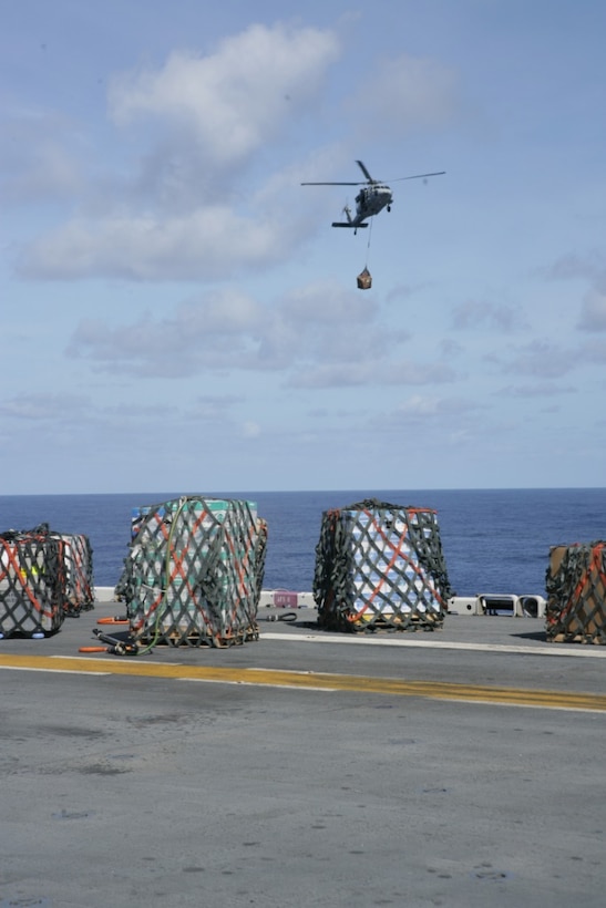 A Navy HH-60H Seahawk flies fresh food, mail and other supplies onto the USS Iwo Jima (LHD-7) Sept. 7, 2008. After nearly two weeks at sea, the Iwo Jima Expeditionary Strike Group received its first resupply at sea. The resupply brought mail, food and other essential items.