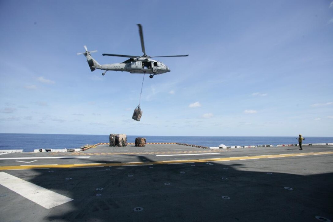 A Navy HH-60H Seahawk flies fresh food, mail and other supplies onto the USS Iwo Jima (LHD-7) Sept. 7, 2008. After nearly two weeks at sea, the Iwo Jima Expeditionary Strike Group received its first resupply at sea. The resupply brought mail, food and other essential items.
